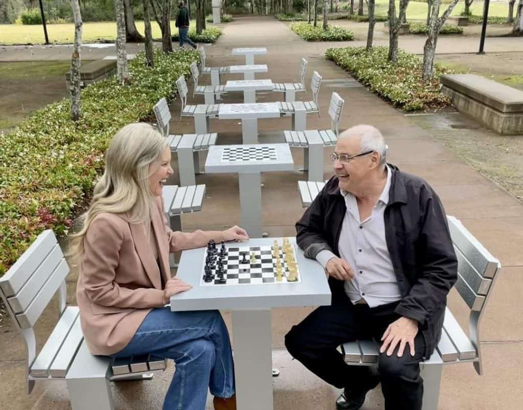 Councillor Nicole Jonic takes on Springfield Ipswich Chess Club’s Ed Cubilla for the inaugural match at newly installed outdoor chess tables.